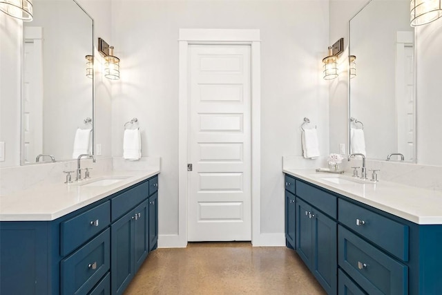 bathroom featuring a sink, baseboards, and two vanities