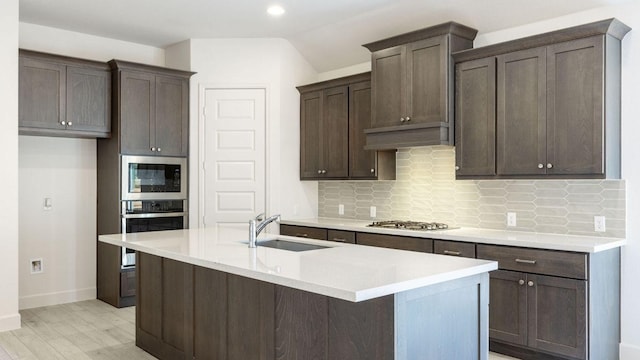 163 Plumbago Loop, Bastrop, TX 78602 - kitchen with stainless steel appliances, a sink, decorative backsplash, light wood-style floors, and recessed lighting