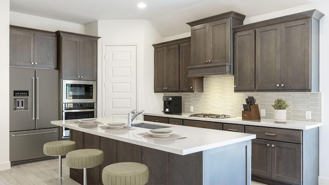 163 Plumbago Loop, Bastrop, TX 78602 - kitchen featuring appliances with stainless steel finishes, a sink, decorative backsplash, lofted ceiling, and recessed lighting