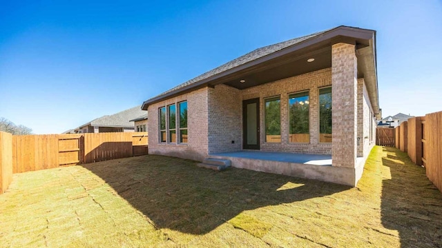 163 Plumbago Loop, Bastrop, TX 78602 - back of house featuring brick siding, a fenced backyard, and a patio area