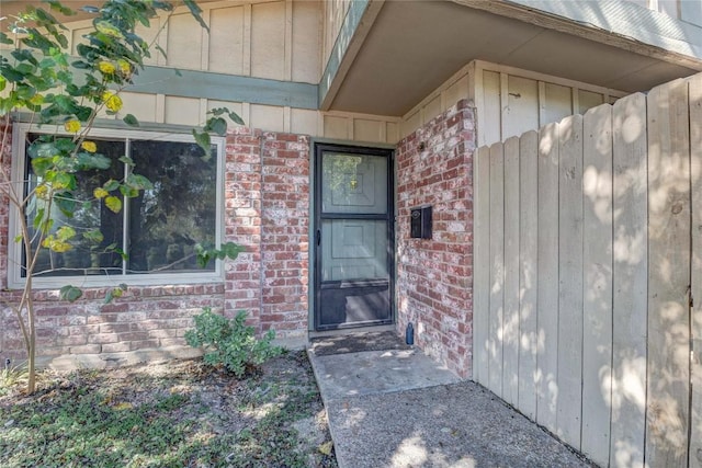 901 E Village Ln, Austin, TX 78758 - doorway to property featuring brick siding and board and batten siding