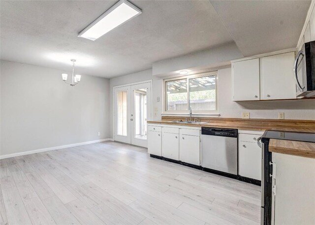 901 E Village Ln, Austin, TX 78758 - kitchen with appliances with stainless steel finishes, a sink, wooden counters, white cabinetry, and a chandelier