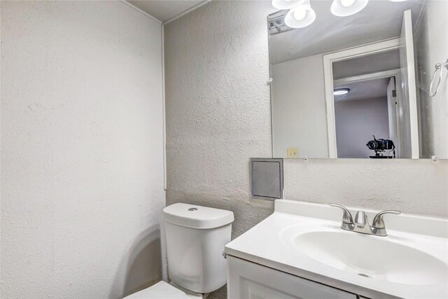 901 E Village Ln, Austin, TX 78758 - bathroom featuring a textured wall, toilet, and vanity