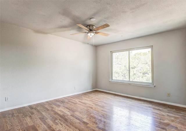 901 E Village Ln, Austin, TX 78758 - spare room with a ceiling fan, wood finished floors, baseboards, and a textured ceiling