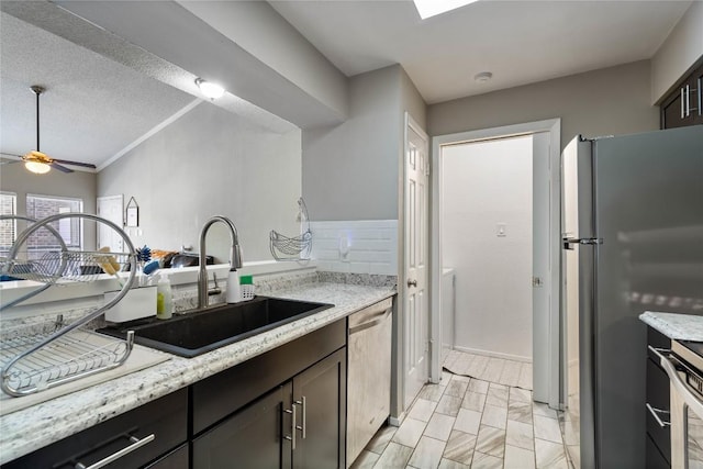 807 W 25th St Unit 307, Austin, TX 78705 - kitchen featuring stainless steel appliances, a ceiling fan, a sink, and light stone countertops