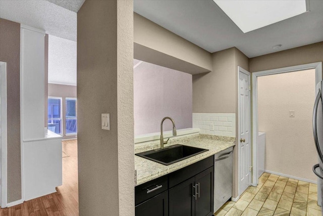 807 W 25th St Unit 307, Austin, TX 78705 - kitchen featuring appliances with stainless steel finishes, dark cabinets, and light stone countertops