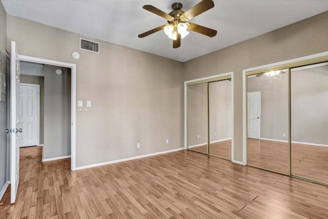 807 W 25th St Unit 307, Austin, TX 78705 - unfurnished bedroom with light wood finished floors, two closets, and ceiling fan