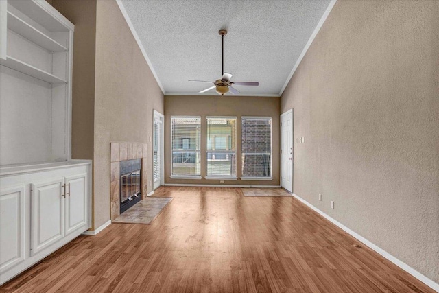 807 W 25th St Unit 307, Austin, TX 78705 - unfurnished living room with a textured wall, a ceiling fan, crown molding, light wood finished floors, and a fireplace
