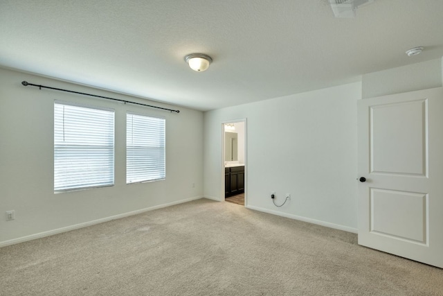 spare room featuring visible vents, light colored carpet, and baseboards