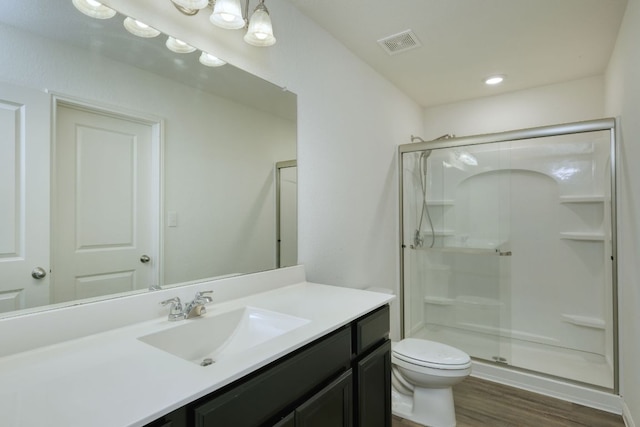 bathroom featuring visible vents, a shower stall, toilet, and wood finished floors