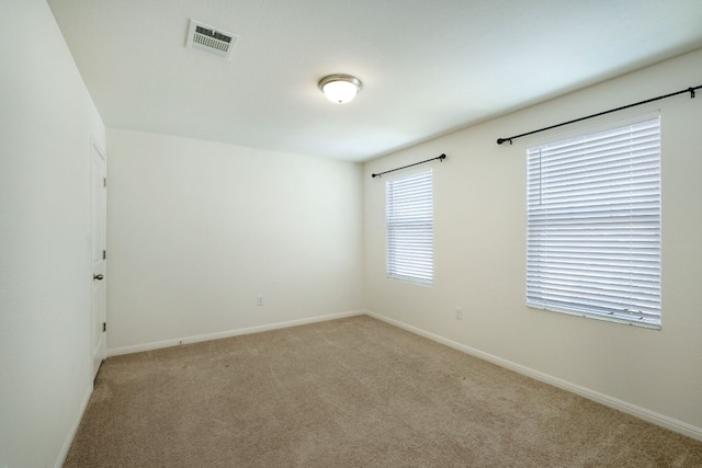 empty room with visible vents, baseboards, and carpet