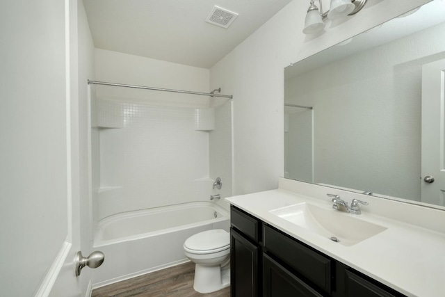 full bathroom featuring vanity, wood finished floors, washtub / shower combination, visible vents, and toilet