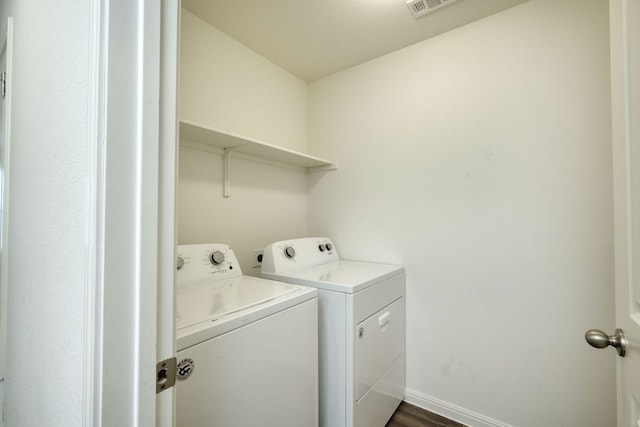 laundry area featuring washer and dryer, laundry area, dark wood finished floors, and baseboards