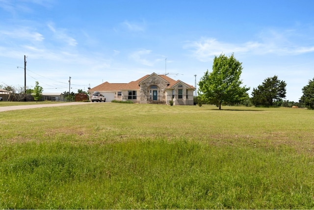341 Brown Rd, Mcdade, TX 78650 - view of front of home with stone siding, driveway, a front lawn, and a garage