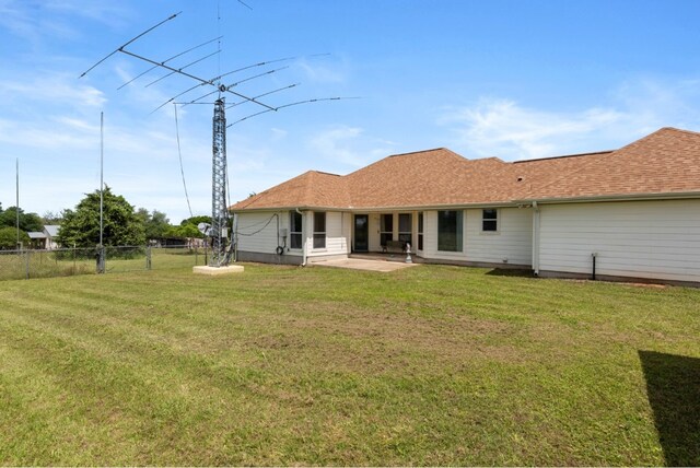 341 Brown Rd, Mcdade, TX 78650 - rear view of house with a patio area, a lawn, a shingled roof, and fence
