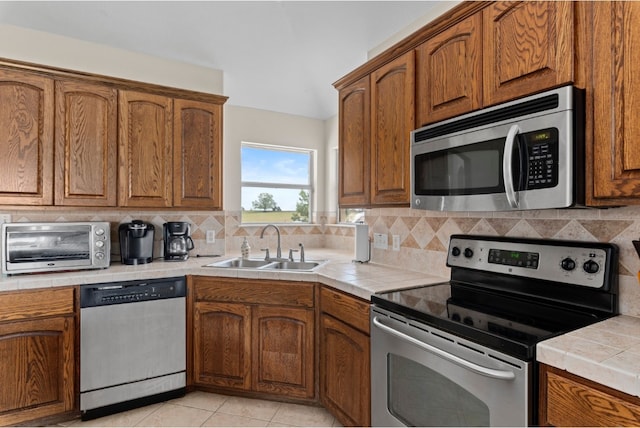 341 Brown Rd, Mcdade, TX 78650 - kitchen with tile countertops, appliances with stainless steel finishes, brown cabinets, and a sink