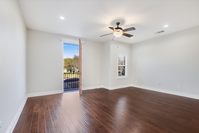 spare room featuring dark wood finished floors, baseboards, and visible vents