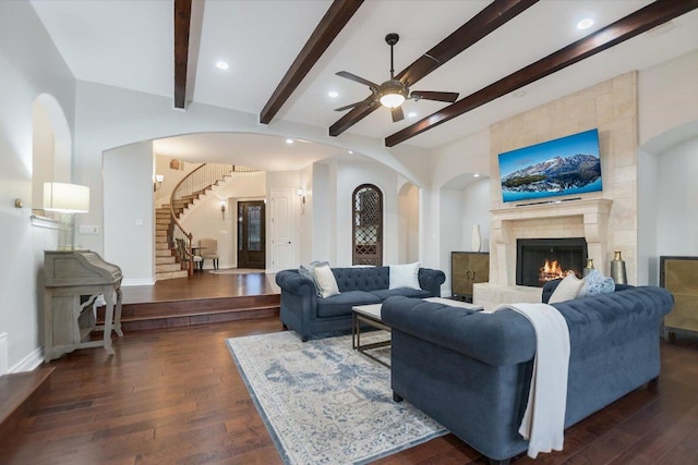211 Jack Nicklaus Dr, Austin, TX 78738 - living room featuring beam ceiling, a ceiling fan, dark wood-style flooring, stairway, and a tiled fireplace
