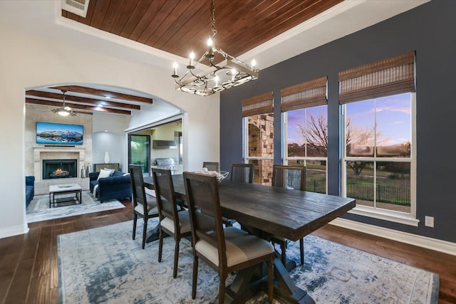 211 Jack Nicklaus Dr, Austin, TX 78738 - dining area with arched walkways, wooden ceiling, a warm lit fireplace, wood-type flooring, and a chandelier