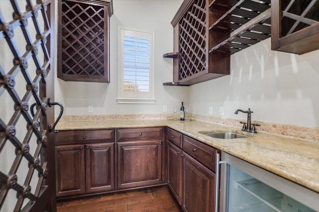 kitchen with light stone counters, beverage cooler, open shelves, dark wood-style flooring, and a sink