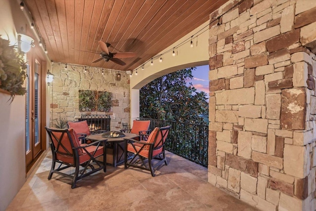 patio terrace at dusk with a fire pit and ceiling fan