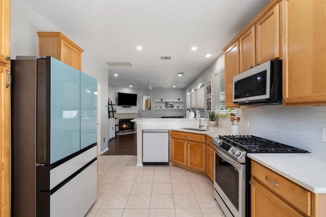 kitchen featuring tasteful backsplash, open floor plan, a peninsula, white appliances, and a sink