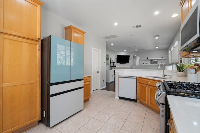 kitchen featuring white appliances, a sink, open floor plan, a peninsula, and a ceiling fan