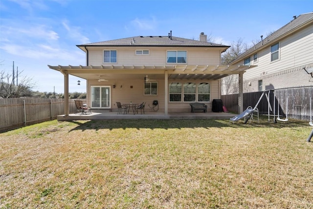 rear view of house with a yard, a fenced backyard, a chimney, ceiling fan, and a patio area