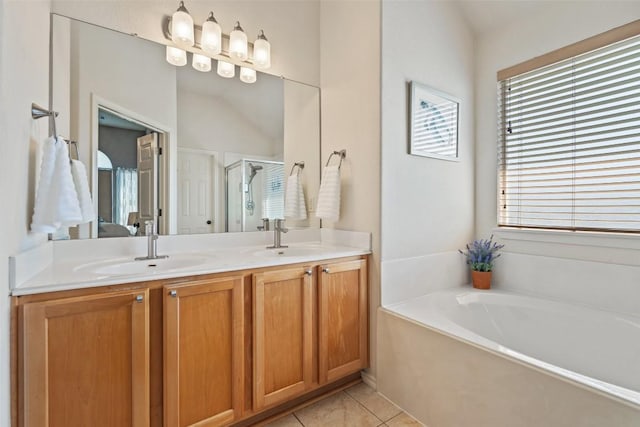 ensuite bathroom featuring tile patterned flooring, a shower stall, double vanity, and a sink