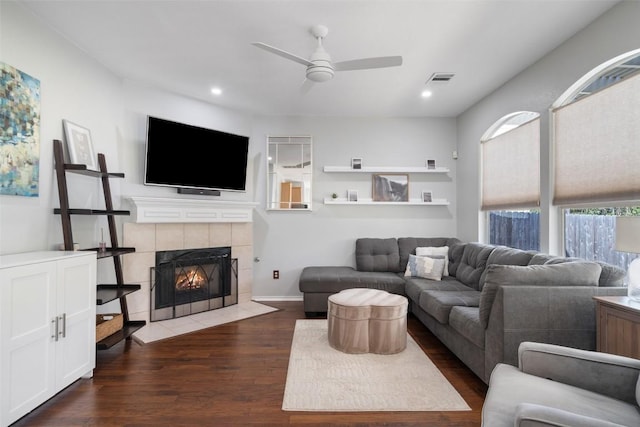 living area featuring visible vents, a tiled fireplace, wood finished floors, recessed lighting, and ceiling fan