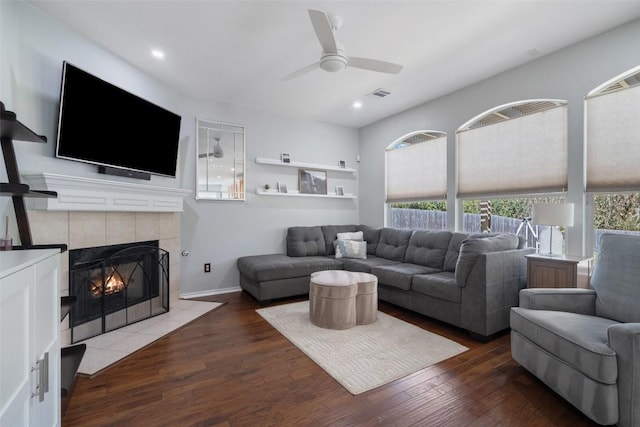 living area with visible vents, plenty of natural light, a fireplace, and wood finished floors