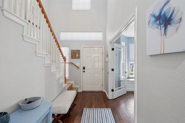 entrance foyer with baseboards, stairs, a high ceiling, and hardwood / wood-style floors