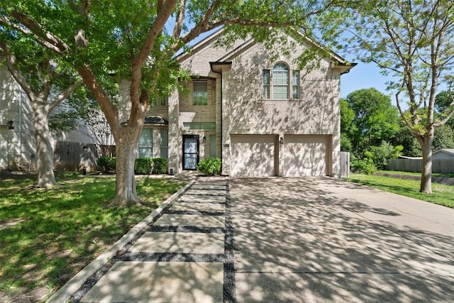traditional-style house with driveway, an attached garage, and brick siding