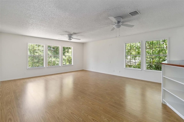 4320 Dos Cabezas Dr, Austin, TX 78749 - unfurnished room featuring ceiling fan, a textured ceiling, wood finished floors, healthy amount of natural light, and baseboards