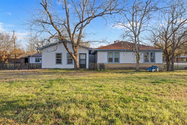 631 S Harris St, Giddings, TX 78942 - back of house with a yard, brick siding, cooling unit, and fence