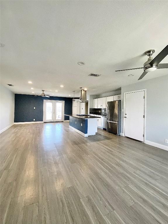 8602 Colonial Dr, Austin, TX 78758 - unfurnished living room featuring wood finished floors, recessed lighting, ceiling fan, and french doors