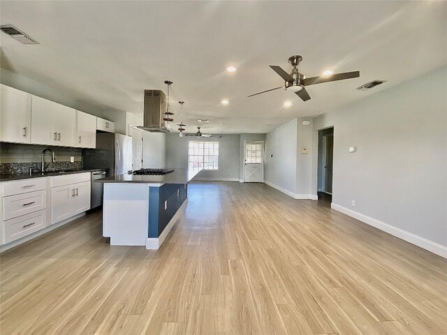8602 Colonial Dr, Austin, TX 78758 - kitchen featuring island range hood, appliances with stainless steel finishes, open floor plan, ceiling fan, and white cabinetry