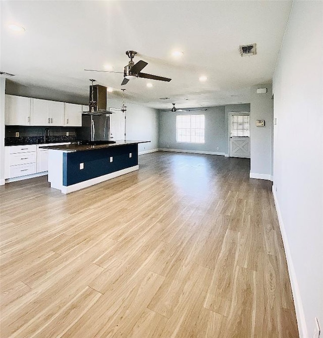 8602 Colonial Dr, Austin, TX 78758 - unfurnished living room with a ceiling fan, baseboards, light wood-type flooring, recessed lighting, and a sink