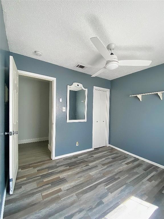 8602 Colonial Dr, Austin, TX 78758 - unfurnished bedroom featuring wood finished floors, a closet, a textured ceiling, and ceiling fan