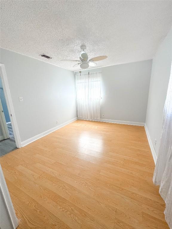 8602 Colonial Dr, Austin, TX 78758 - spare room featuring light wood finished floors, ceiling fan, a textured ceiling, and baseboards