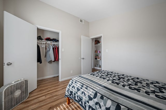 bedroom featuring a closet, visible vents, baseboards, and light wood-style floors