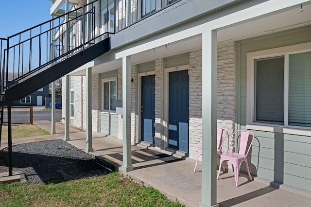 doorway to property featuring stone siding and covered porch
