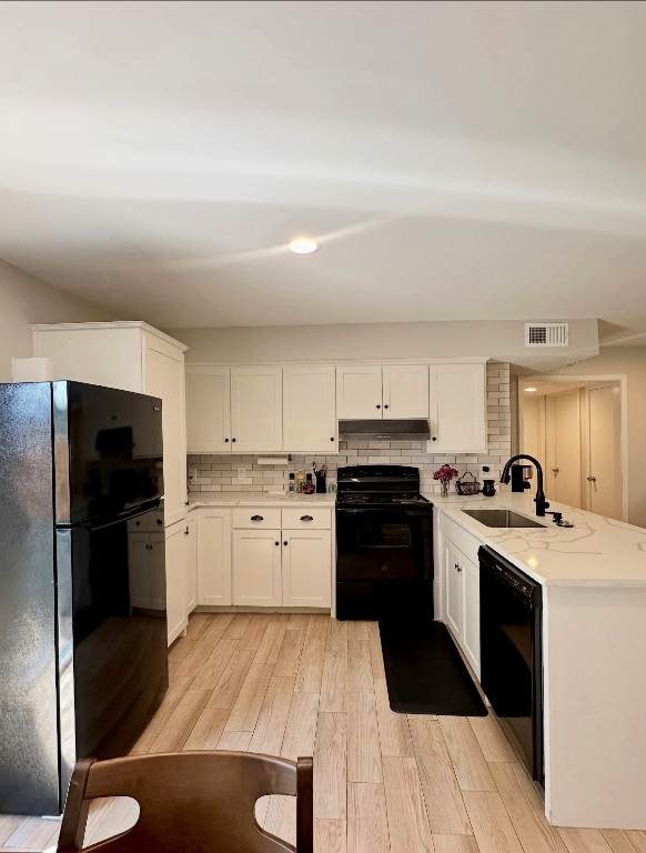 kitchen with visible vents, a sink, black appliances, white cabinetry, and tasteful backsplash