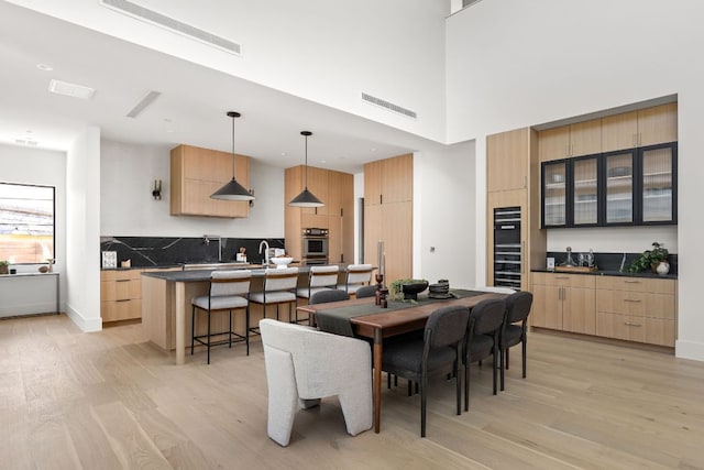 6102 Forest Hills Dr, Austin, TX 78746 - dining room with light wood-style floors, bar, and a towering ceiling