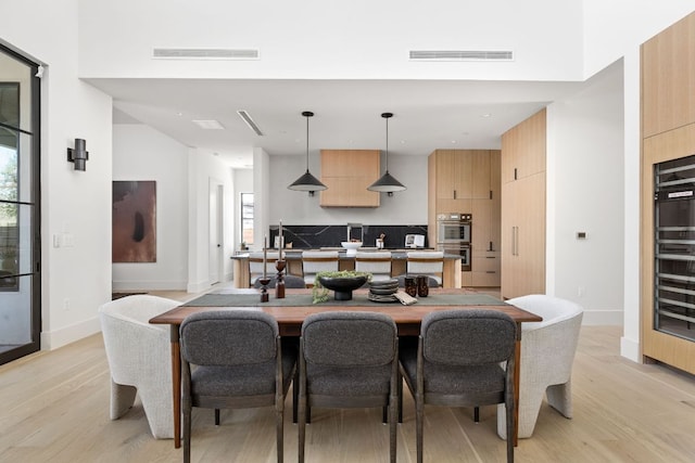 6102 Forest Hills Dr, Austin, TX 78746 - dining space featuring light wood-style floors, wine cooler, and recessed lighting
