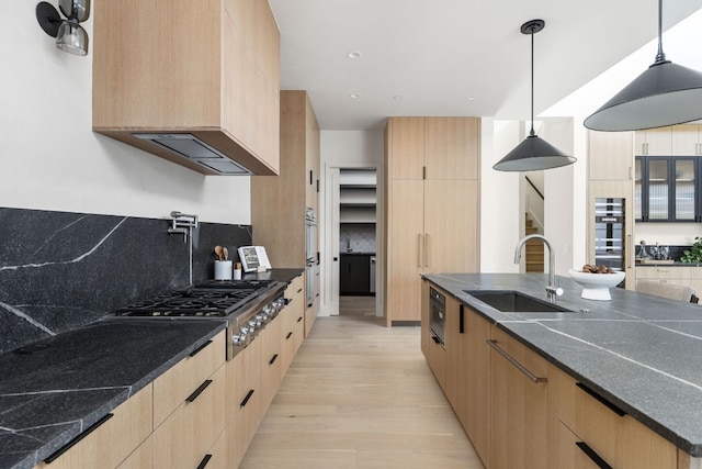 6102 Forest Hills Dr, Austin, TX 78746 - kitchen with stainless steel gas cooktop, light brown cabinetry, light wood-style floors, modern cabinets, and custom exhaust hood