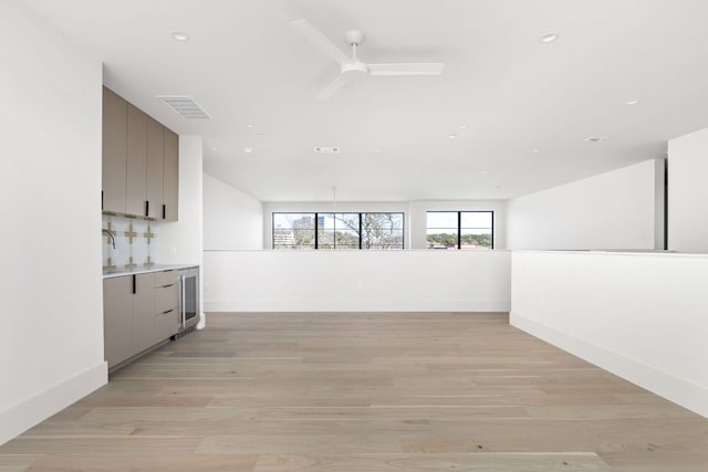 6102 Forest Hills Dr, Austin, TX 78746 - unfurnished living room featuring bar, a ceiling fan, recessed lighting, wine cooler, and light wood-style flooring
