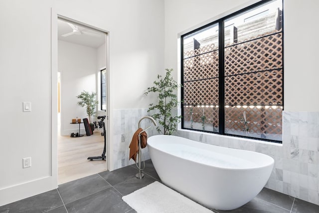 6102 Forest Hills Dr, Austin, TX 78746 - full bath featuring tile walls, a freestanding tub, tile patterned flooring, and wainscoting