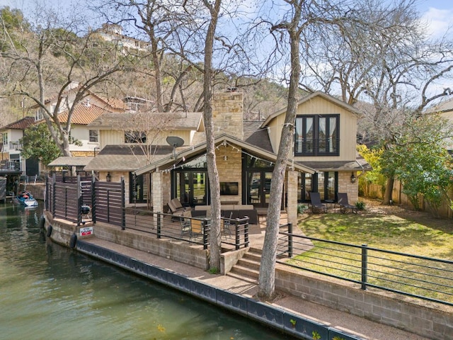 6702 Elfland Dr, Austin, TX 78746 - rear view of property featuring a chimney, a water view, a fenced backyard, and a shingled roof