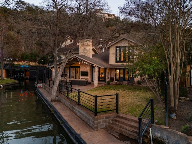 6702 Elfland Dr, Austin, TX 78746 - back of house featuring a chimney, a water view, and an outdoor hangout area